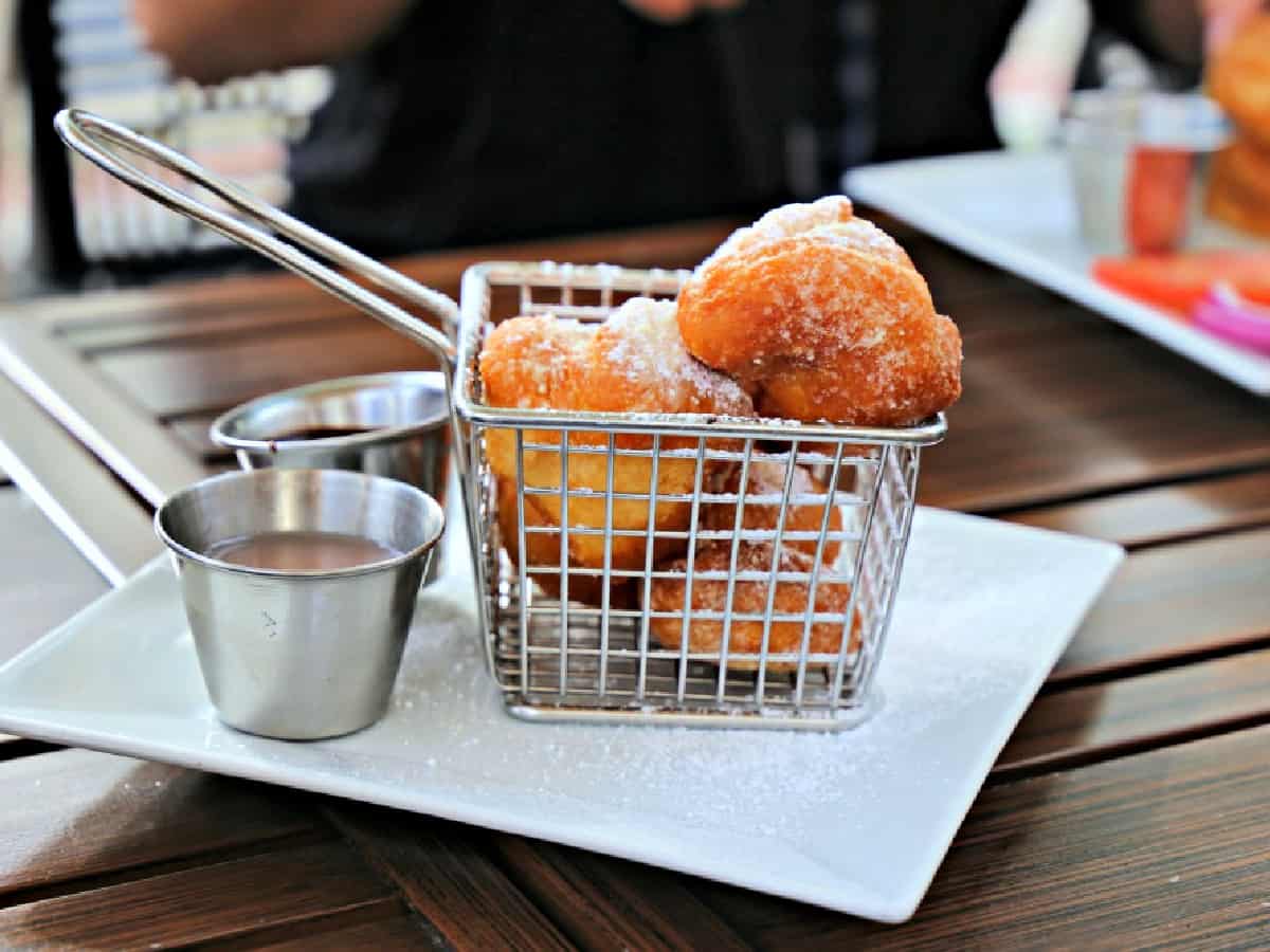 Beignets in a wire basket.