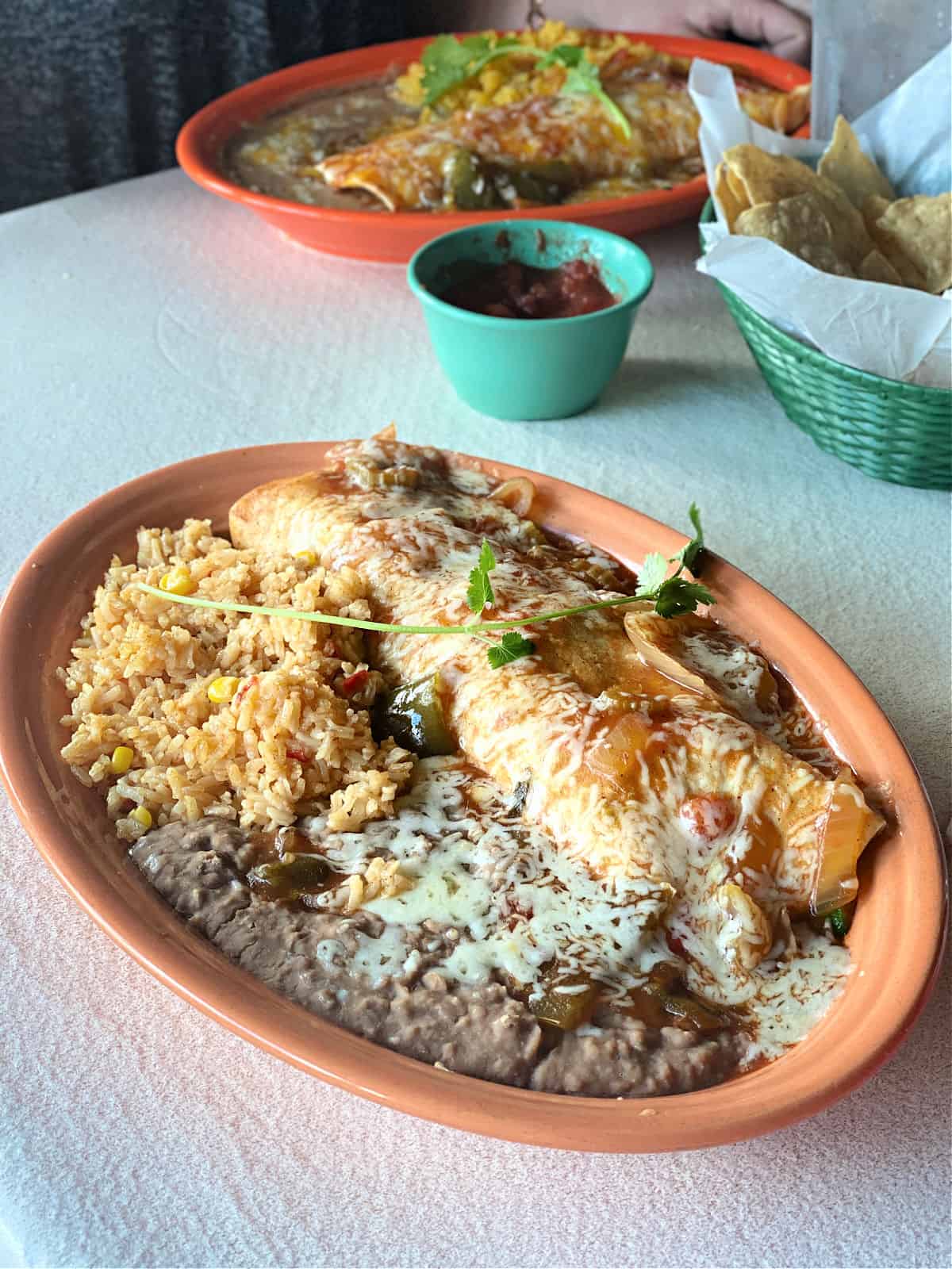 Smothered burrito served with Mexican rice, refried beans, tortilla chips, and salsa at Rosie's Cantina in Florence, Alabama.