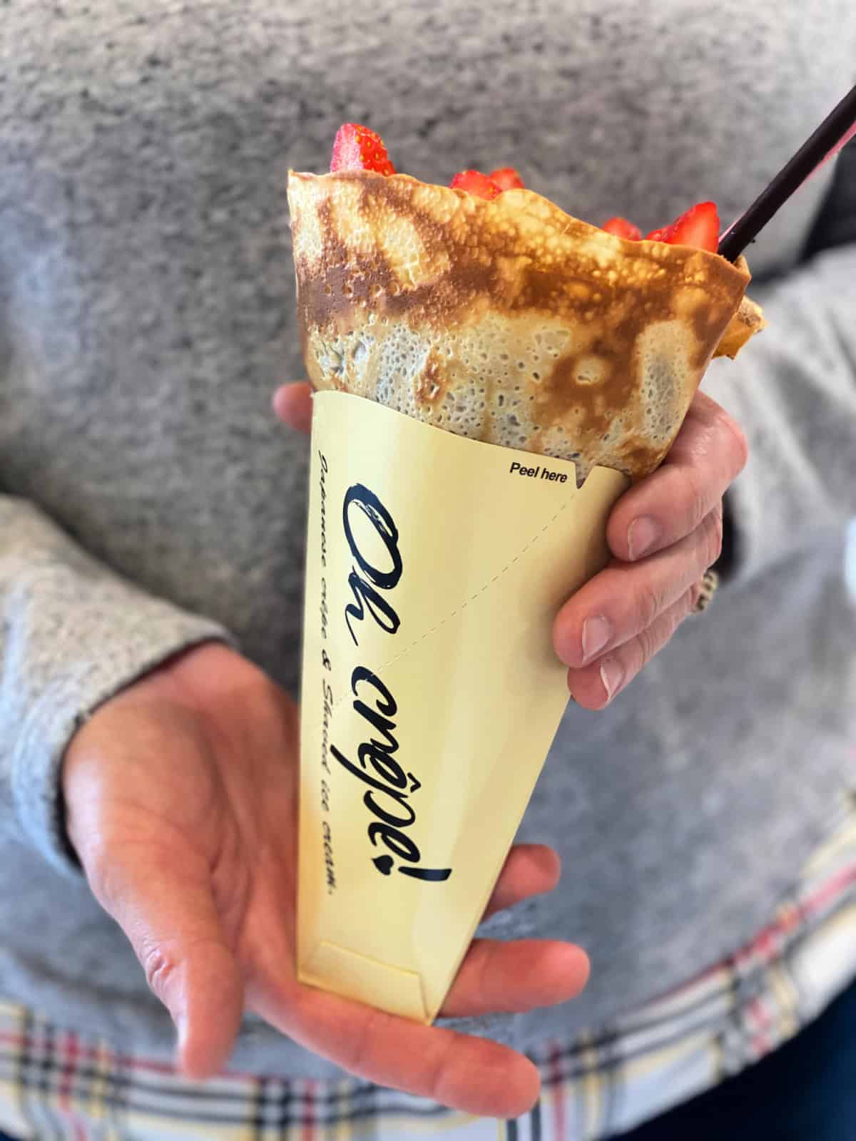 Woman holding a strawberry crepe.