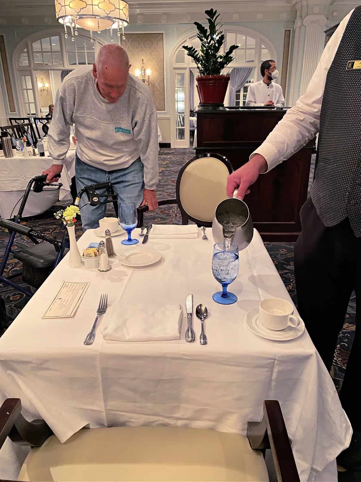 Waiter pouring a glass of water.