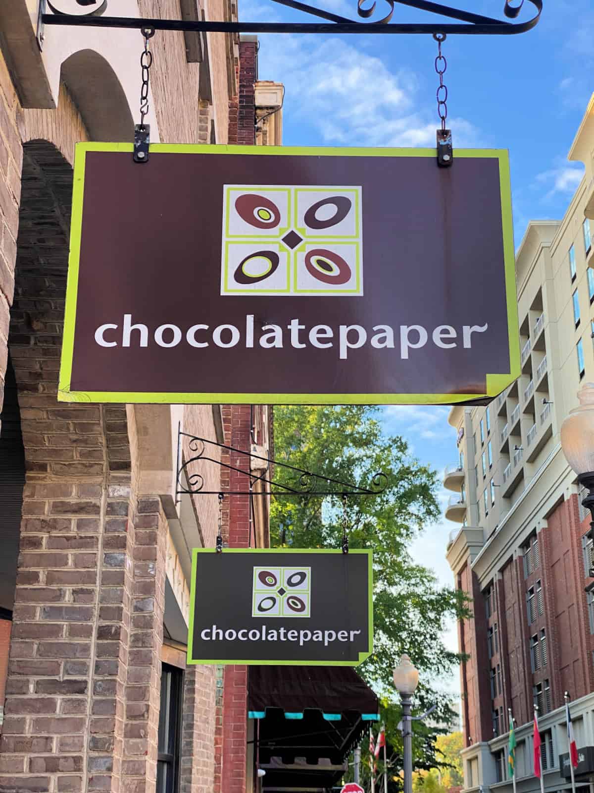 Chocolate Paper sign hanging from a building.