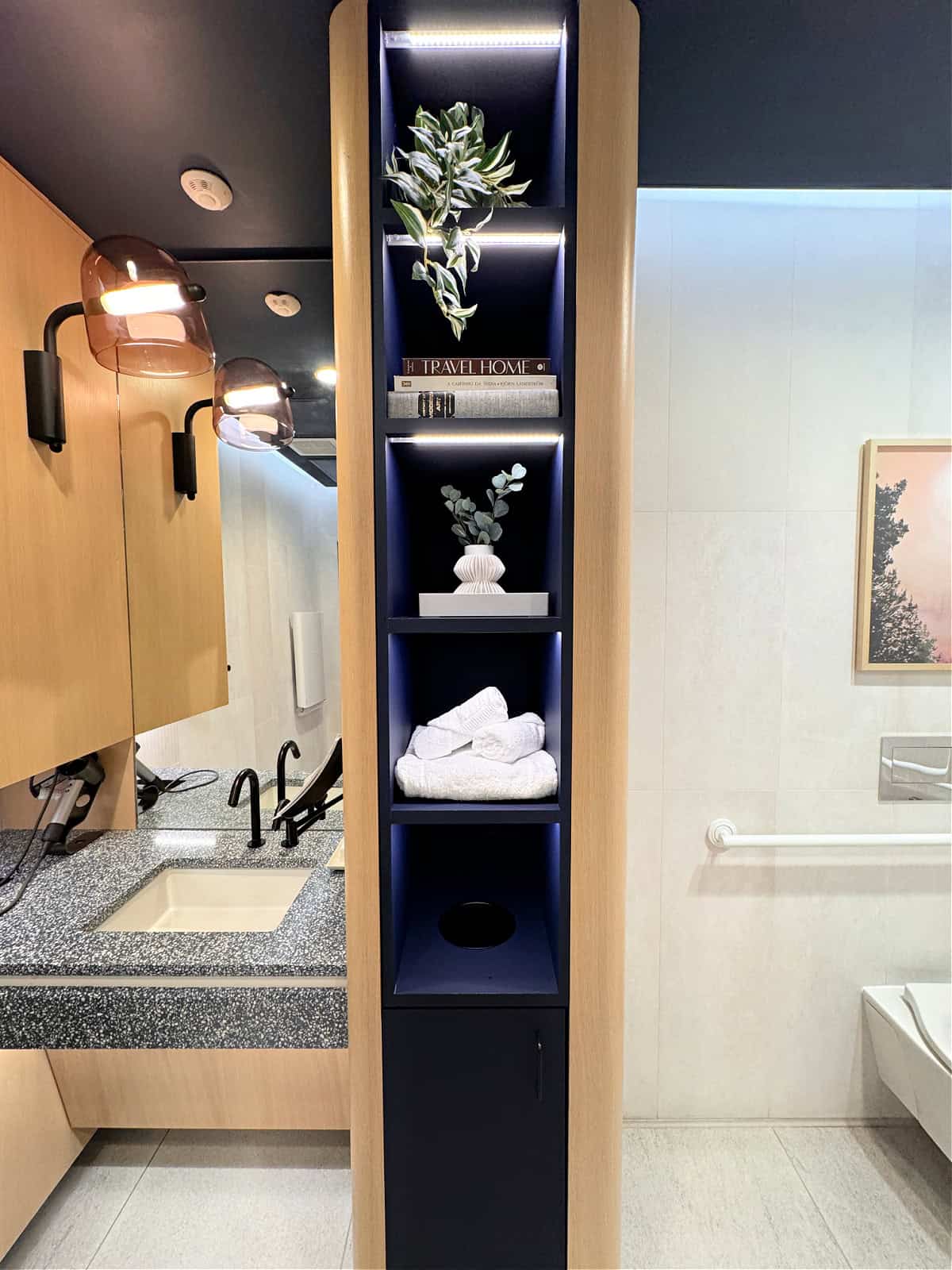 Bathroom with sink, hair dryer, toilet, and towels.