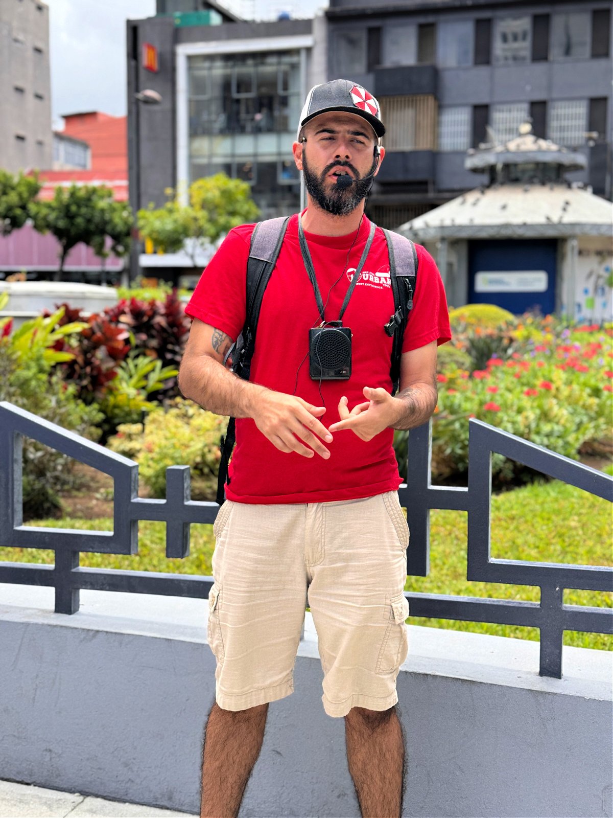 A man in a red shirt with a speaker and microphone.