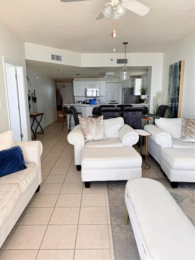 Condo living room in the foreground and condo kitchen in the background.