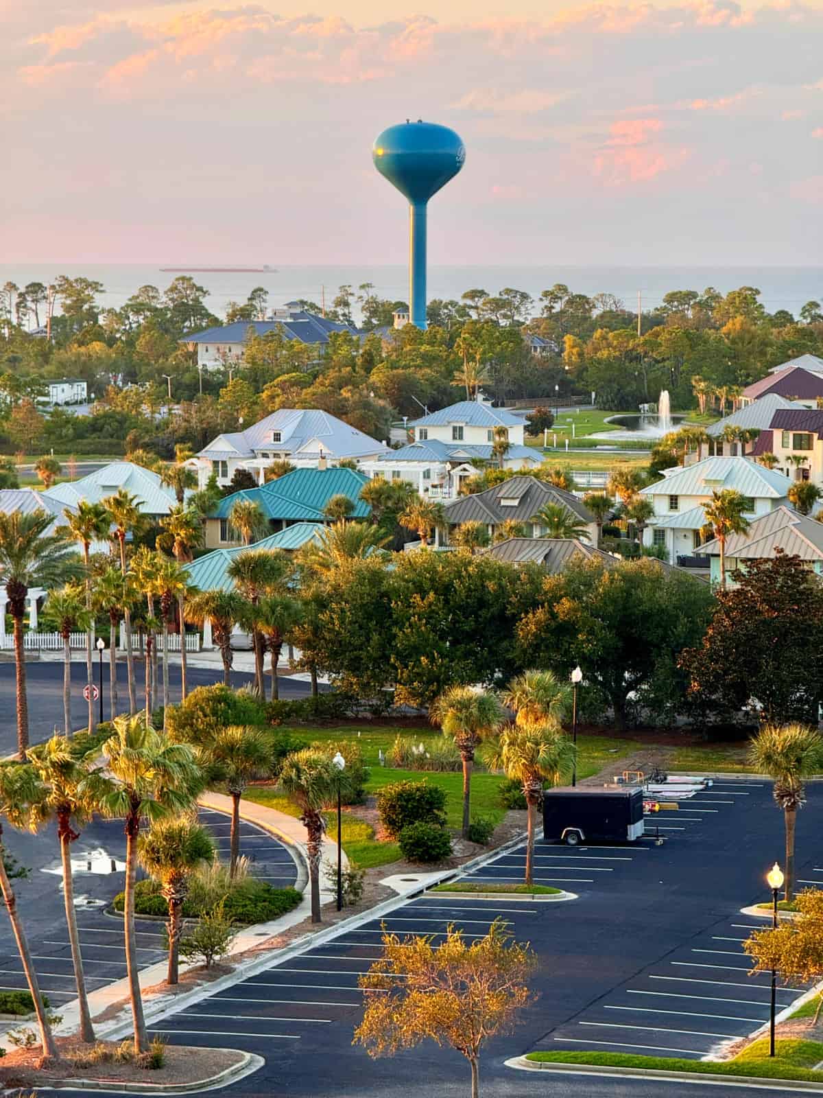 View of a blue water tower in the distance and a parking lot in the foreground.