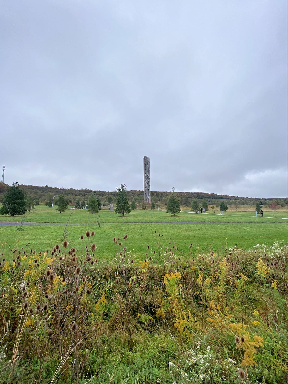 Distant view of the Tower of Voices monument in a field.