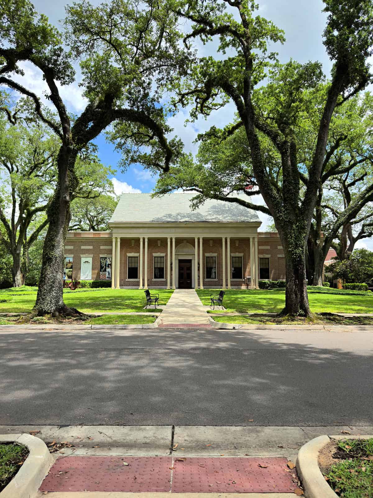 Museum in a brick building with large trees in the front.