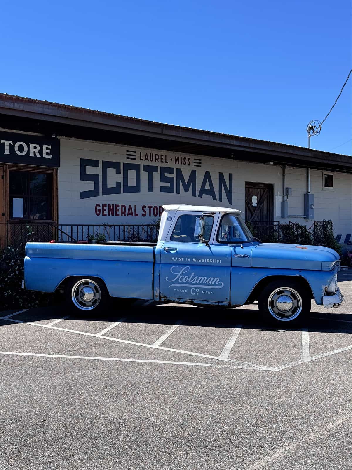 Blue truck in front of a building that says "Scotsman."