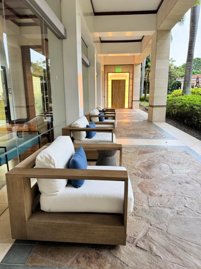 Comfortable outdoor seating area with cushioned chairs under a covered walkway beside the pool at InterContinental San Jose.