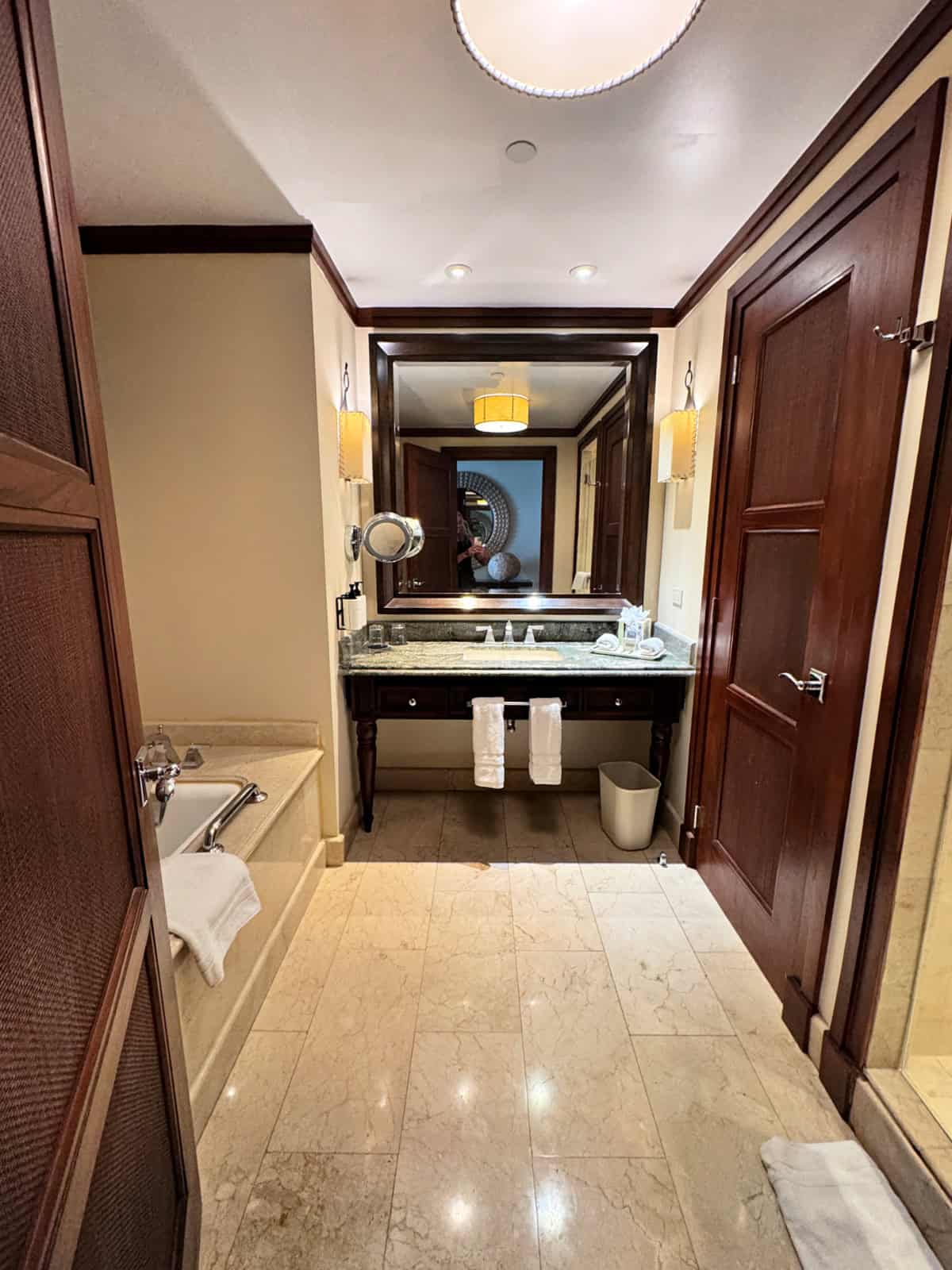 Marble bathroom featuring a soaking tub and glass walk-in shower.