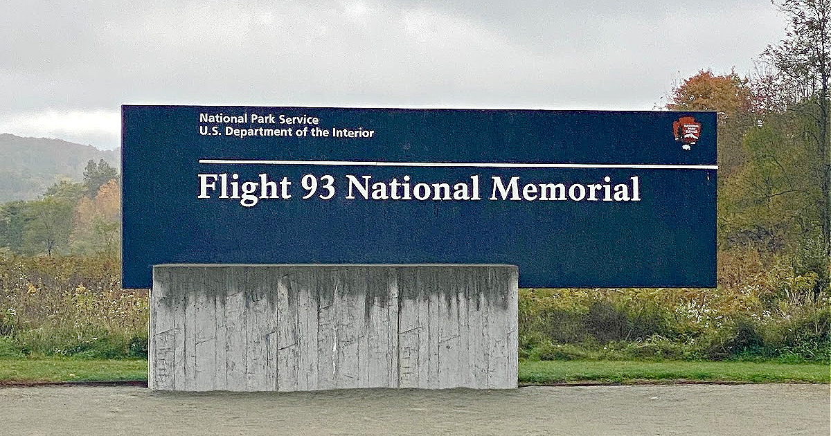 Entrance sign for the Flight 93 National Memorial, displaying the National Park Service logo, set against rolling hills and autumn trees in Shanksville, Pennsylvania.