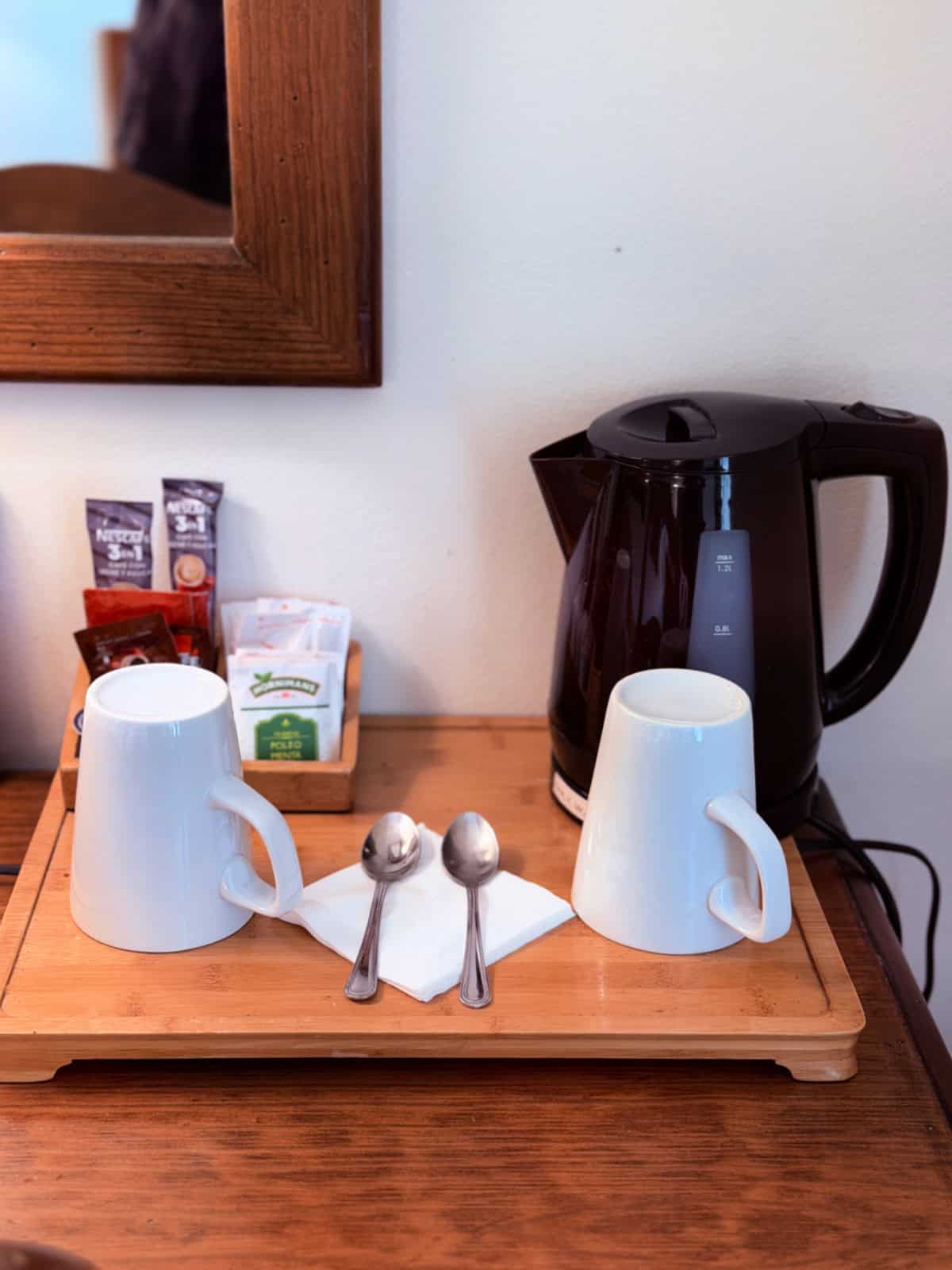 Coffee and tea station with electric kettle, mugs, and complimentary beverages in a guest room at Hotel Airas Nunes.