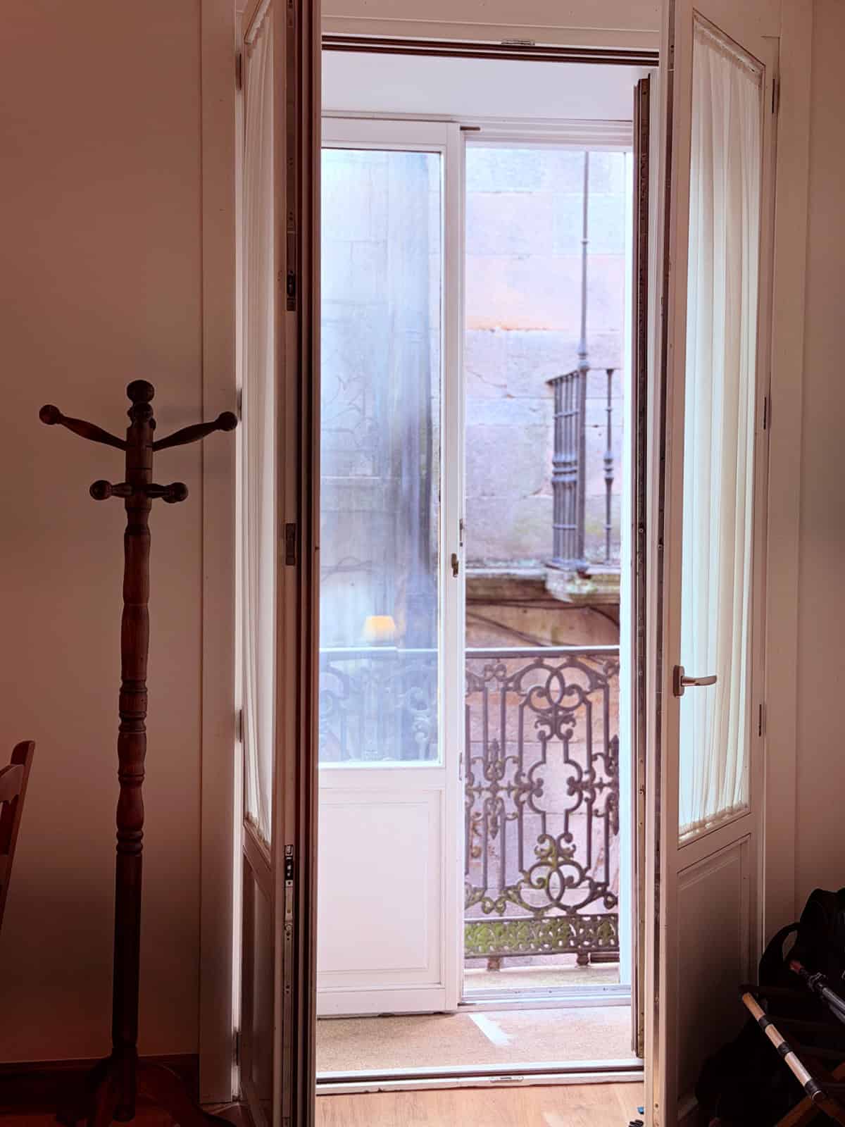 French doors opening to a wrought-iron Juliet balcony overlooking the historic streets of Santiago de Compostela.