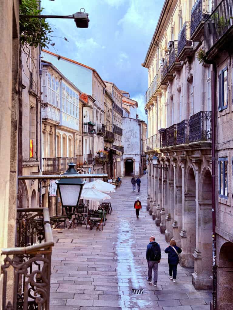 Morning view from Hotel Airas Nunes overlooking a pedestrian street lined with stone arcades and historic buildings in Santiago de Compostela.