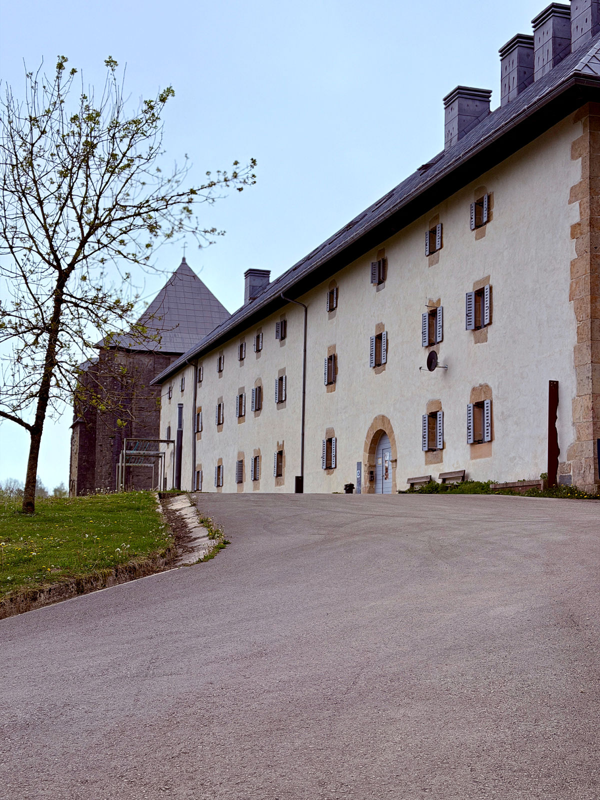 Historic pilgrims' hostel complex in Roncesvalles, Spain, with stone architecture and a long white façade that welcomes Camino de Santiago walkers at the end of the Pyrenees crossing.