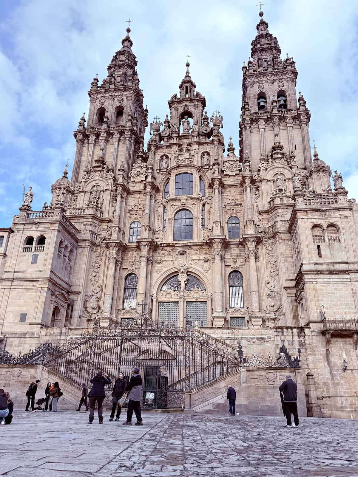 Front façade of Santiago de Compostela Cathedral with its ornate Baroque towers rising above Obradoiro Square.