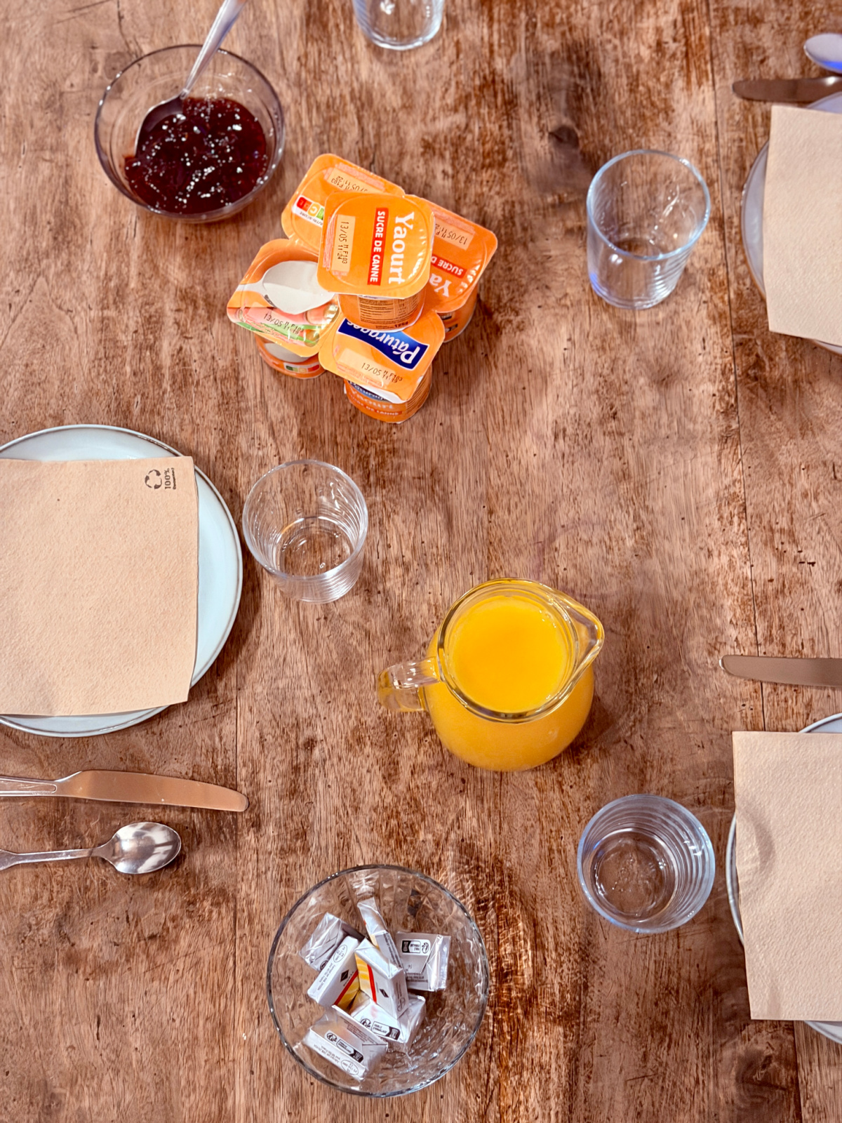Simple Camino breakfast with yogurt, orange juice, jam, and bread served at Auberge Borda.