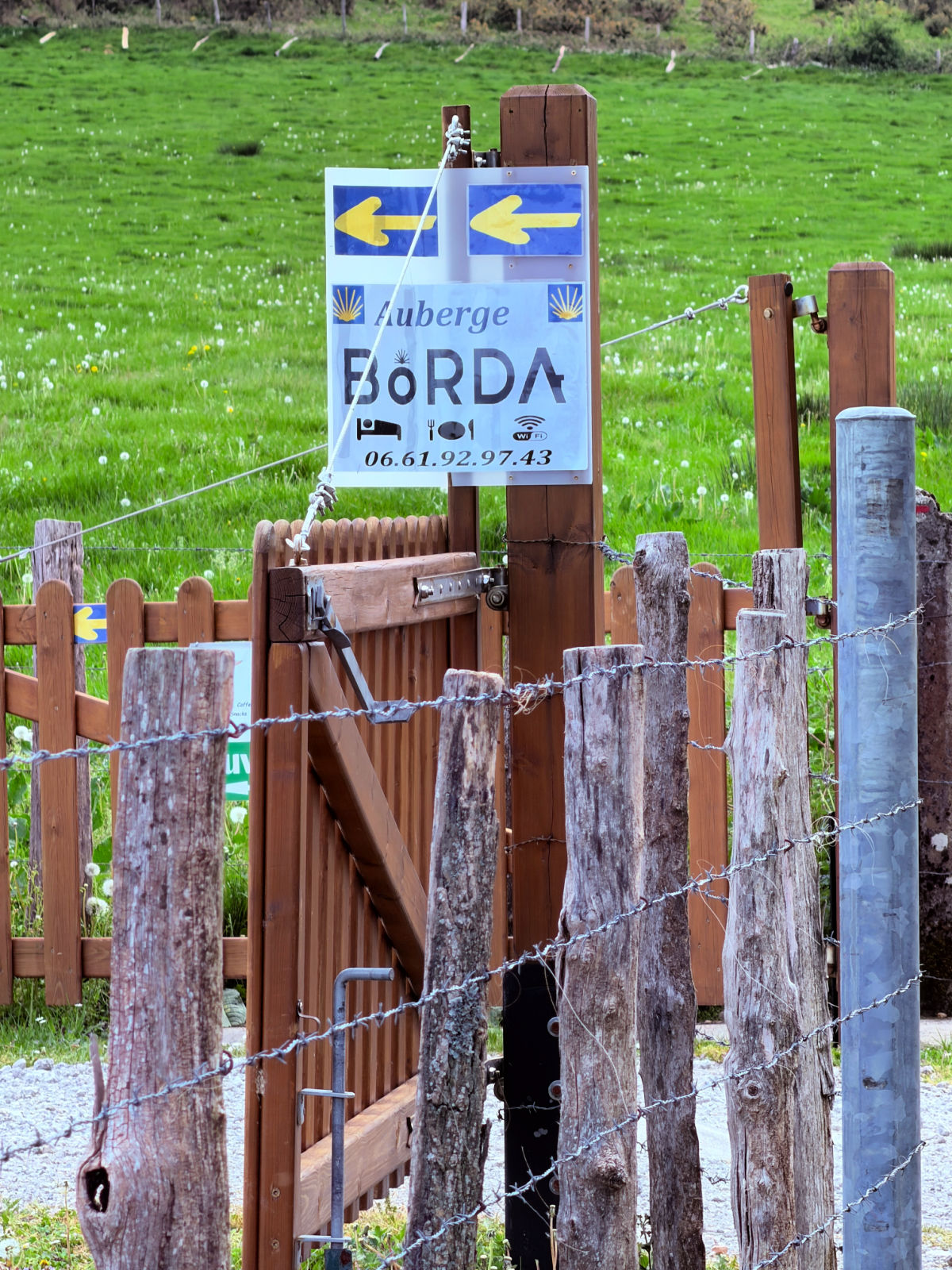 Camino sign for Auberge Borda in Honto welcoming pilgrims on the Camino de Santiago.