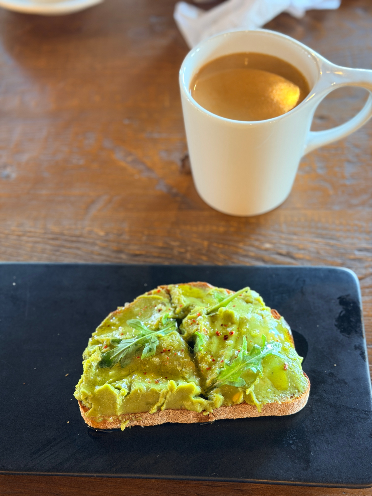 Avocado toast topped with olive oil and greens served with traditional cardamom coffee at Jaizon Coffee in Florence, Alabama.
