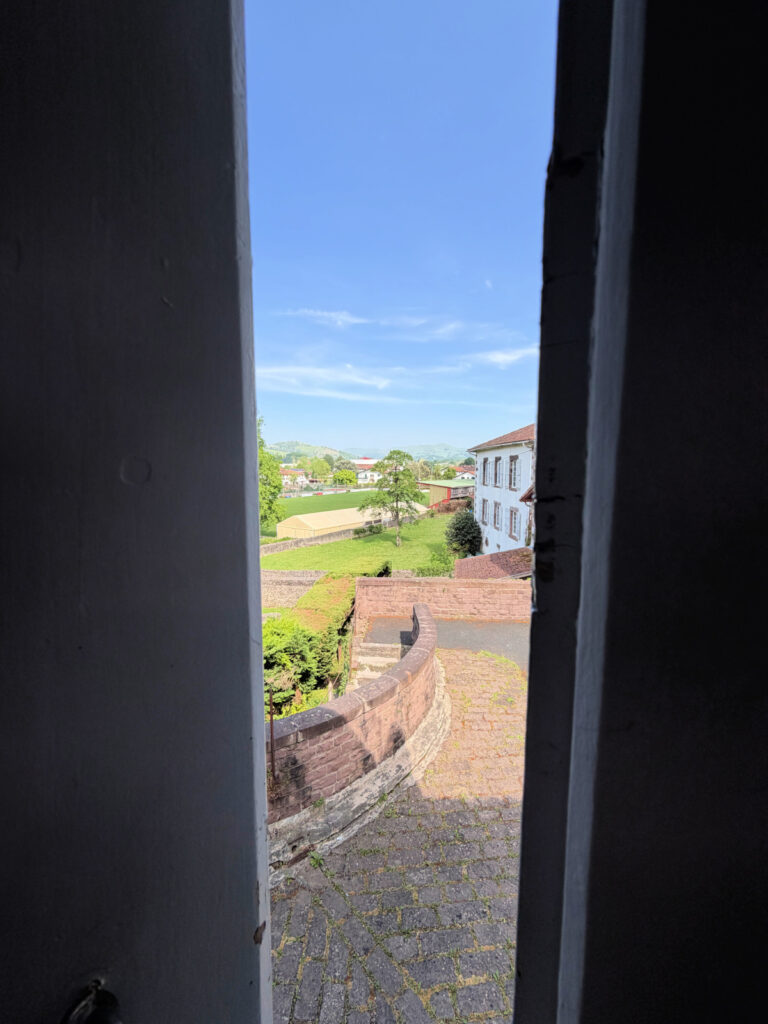 View through the window at Hotel La Villa Esponda overlooking the historic ramparts and surrounding countryside of Saint-Jean-Pied-de-Port.