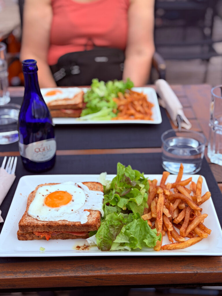 Croque madame with a fried egg served with French fries and green salad at a restaurant along the Camino.