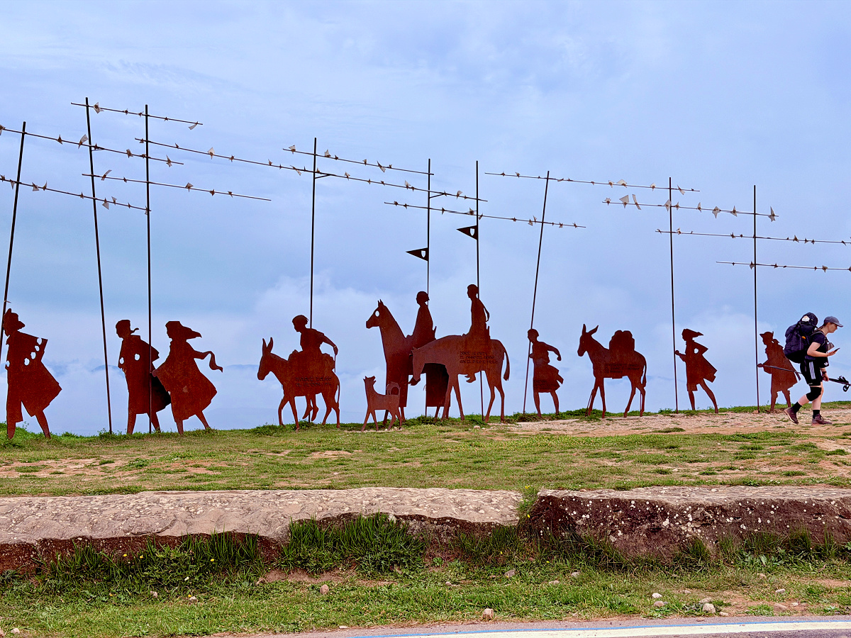 Metal silhouettes of medieval pilgrims at the Alto del Perdón monument along the Camino de Santiago.