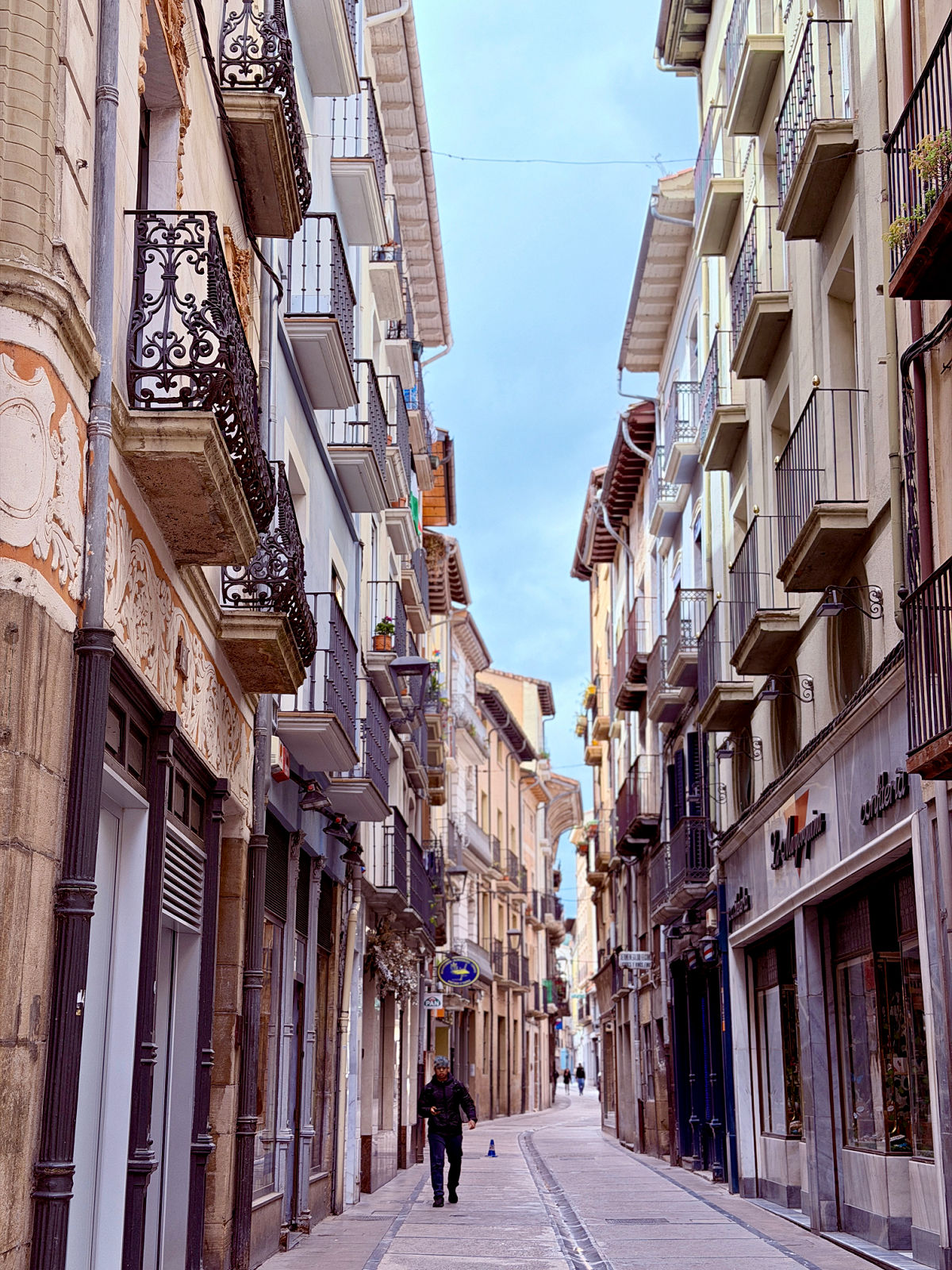 Narrow historic street lined with stone buildings and balconies in Estella, Spain.