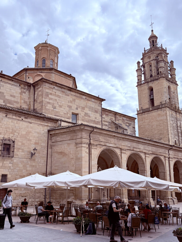 Church and outdoor café tables in the town square of Los Arcos, Spain.