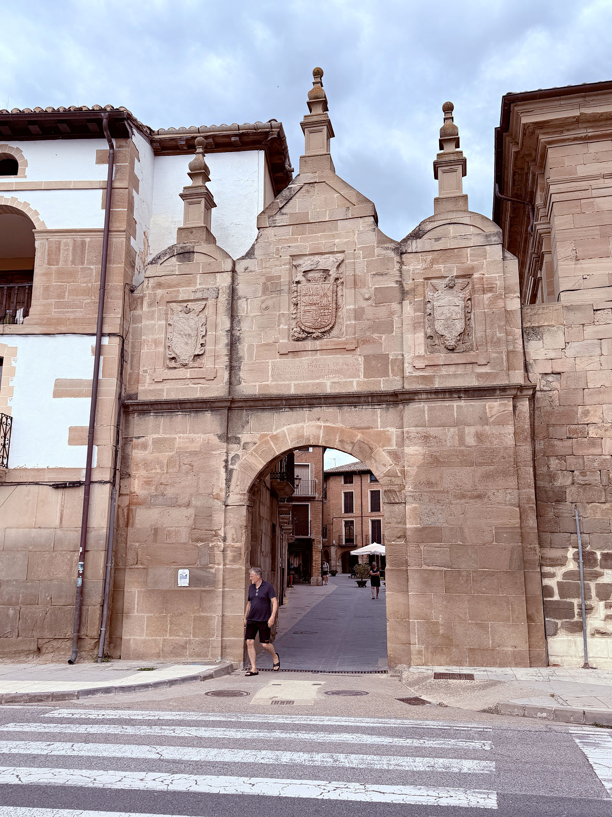 Ornate stone gateway leading into the historic center of Los Arcos, Spain.