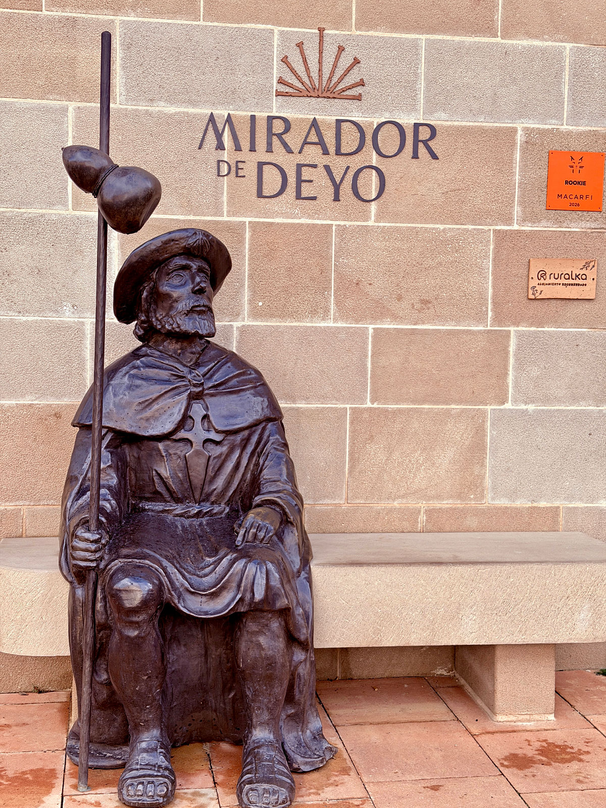 Bronze pilgrim statue seated outside Mirador de Deyo along the Camino de Santiago.