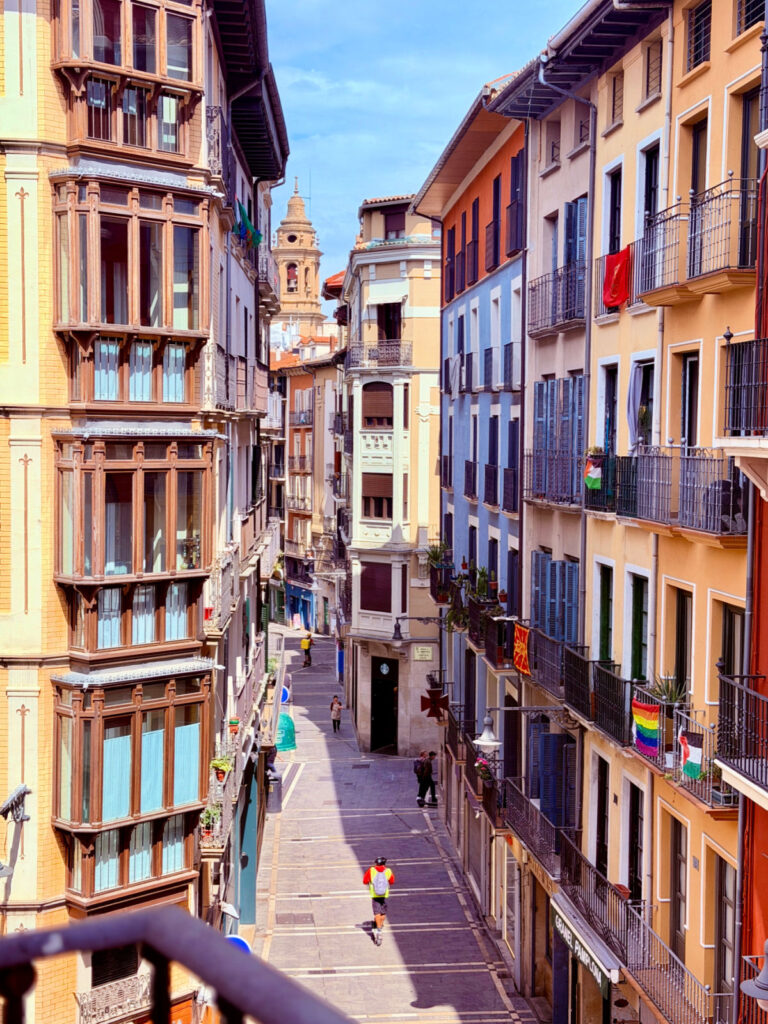 Narrow pedestrian street lined with colorful buildings and balconies in Pamplona’s Old Town.
