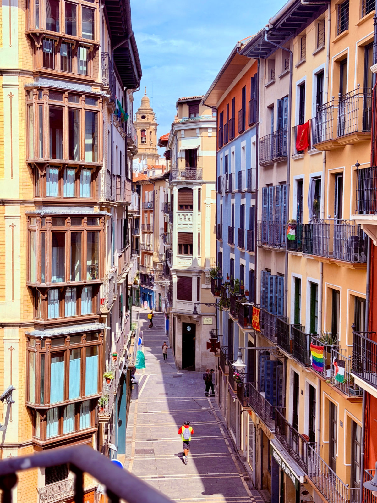 Narrow pedestrian street lined with colorful buildings and balconies in Pamplona’s Old Town.