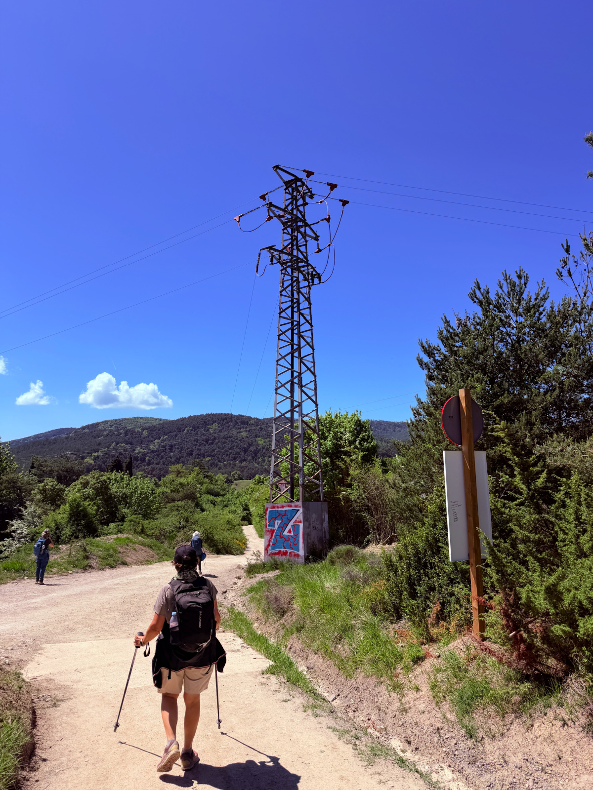 Camino trail crossing the Spanish countryside beneath power lines.