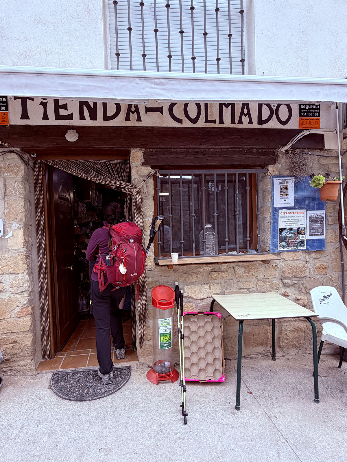 Camino pilgrim entering a small Tienda Colmado grocery store in Spain.