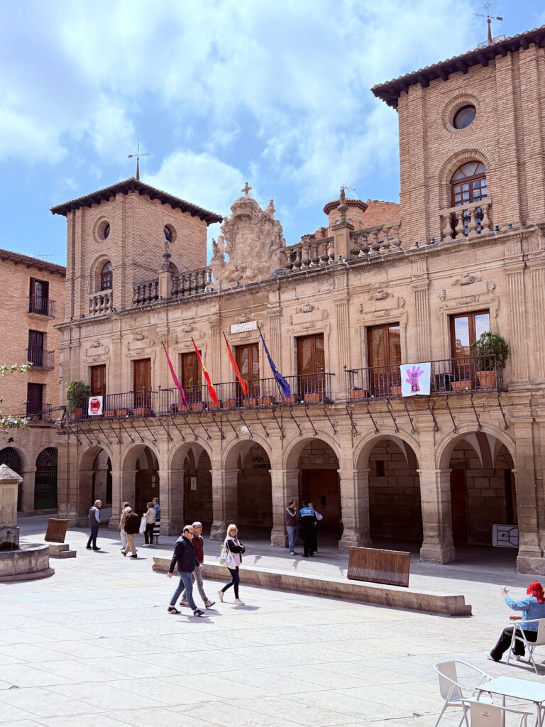 Historic town hall with arched walkways overlooking Plaza de los Fueros in Viana.