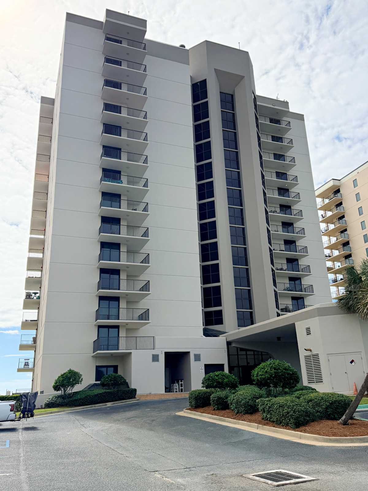 Exterior of the Phoenix East II condo tower and its covered entrance in Orange Beach, Alabama.